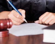 A judge signing papers in a courtroom during a hearing for a client of A-Affordable Bail Bonds, a bail bonds company in Washington State