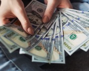 A stack of 100 dollar bills in a woman's hands, representing the bail bonds offered by A-Affordable Bail Bonds in Vancouver, WA