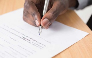 A close-up of a person signing a bail bond agreement at A-Affordable Bail Bonds in Vancouver, WA