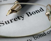 A fountain pen and glasses over a surety bond paper highlighting the surety bond and bail bond services by A-Affordable Bail Bonds in Washington State