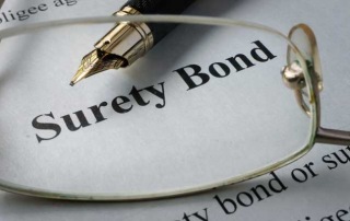 A fountain pen and glasses over a surety bond paper highlighting the surety bond and bail bond services by A-Affordable Bail Bonds in Washington State