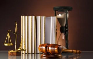 Books, a gavel and a glass timer sitting on a table